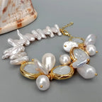 Pearl and gold bracelet on a gray surface with a shell in the background