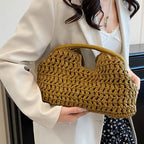 Person holding a mustard yellow woven handbag