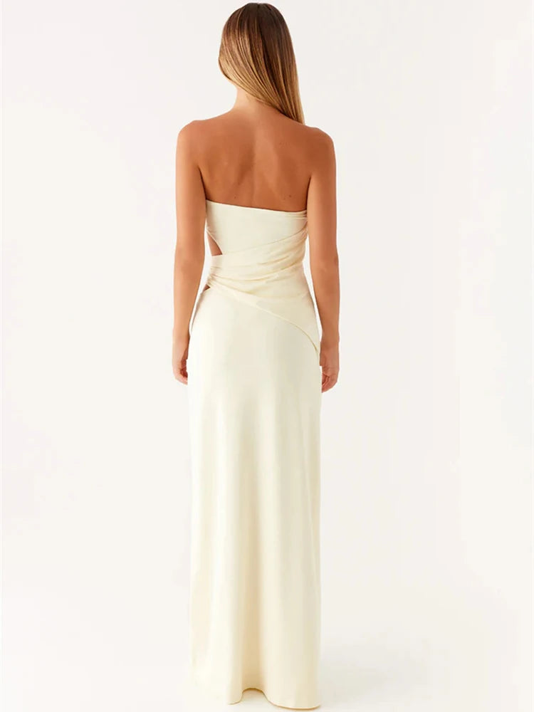 Woman wearing a strapless, floor-length cream dress on a white background