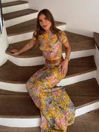 Woman in a floral outfit sitting on a staircase