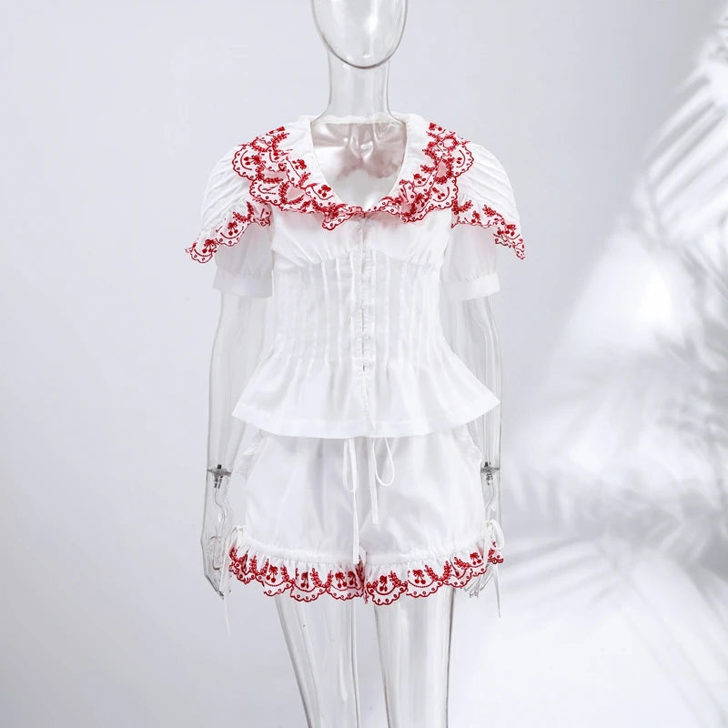 White pajama set with red lace details on a mannequin against a white background