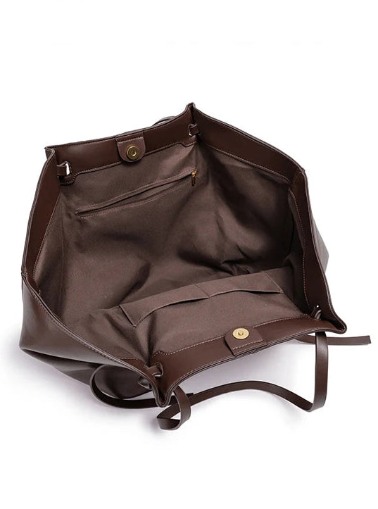 Brown leather bag with open interior on a white background