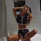 Woman in a black and white outfit posing against a neutral background