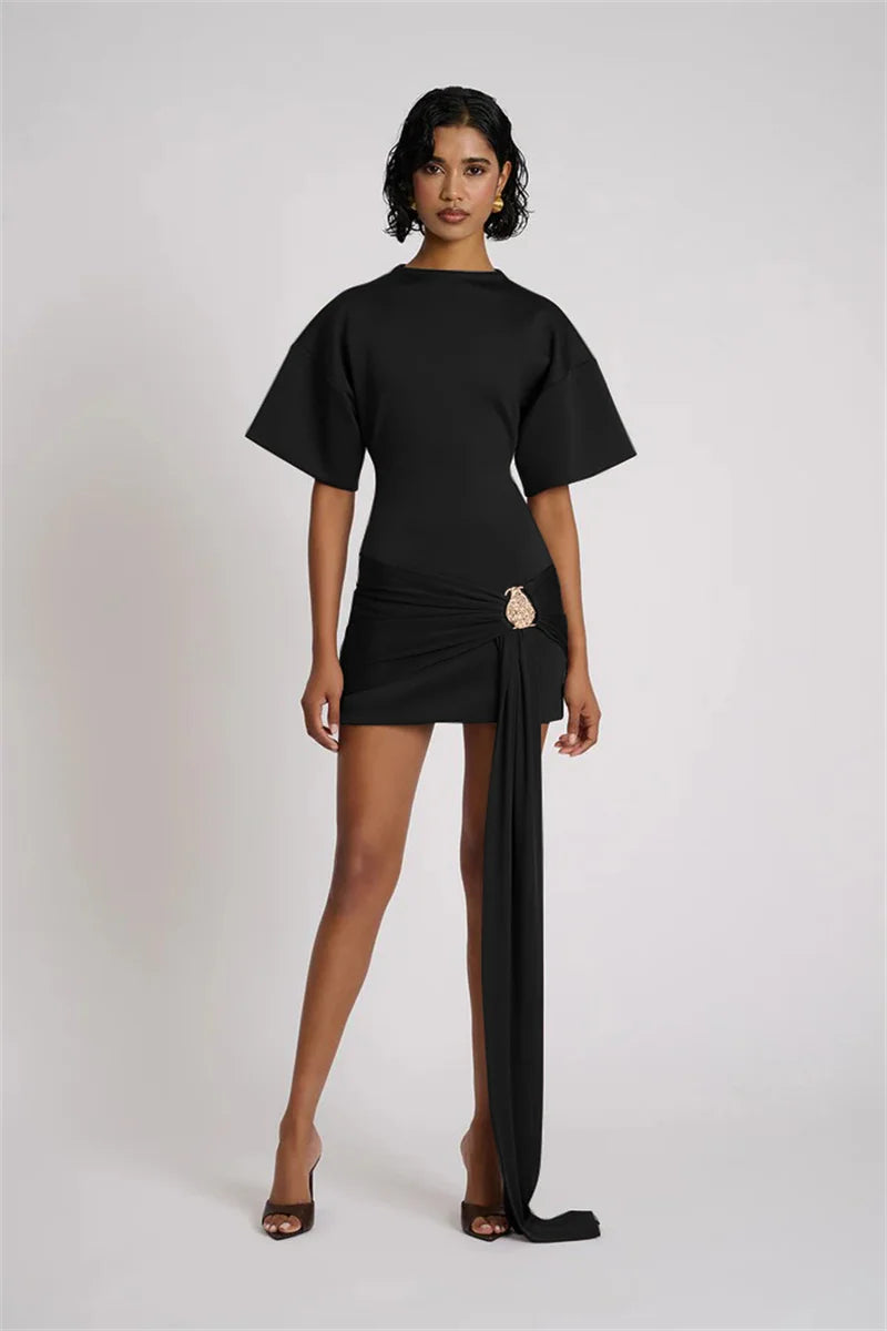 Woman wearing a black outfit with a draped skirt on a white background