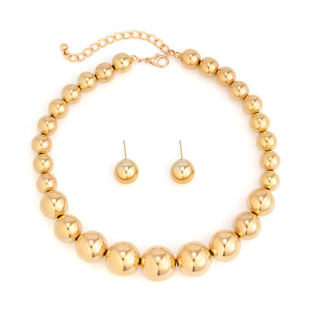 Gold beaded necklace and earrings set on a white background