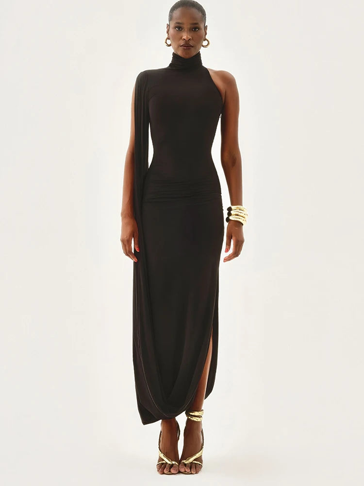 Woman wearing a black dress with a high slit on a white background