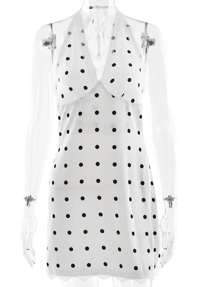 White sleeveless top with black polka dots on a white background
