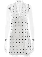 White sleeveless top with black polka dots on a white background