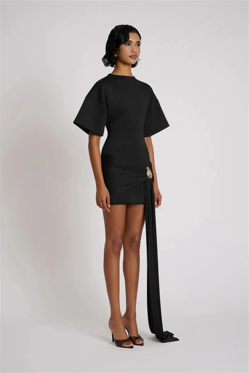 Woman wearing a black outfit with a long black scarf on a white background