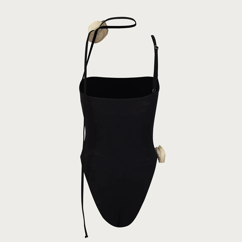 Black swimsuit with thin straps on a light gray background