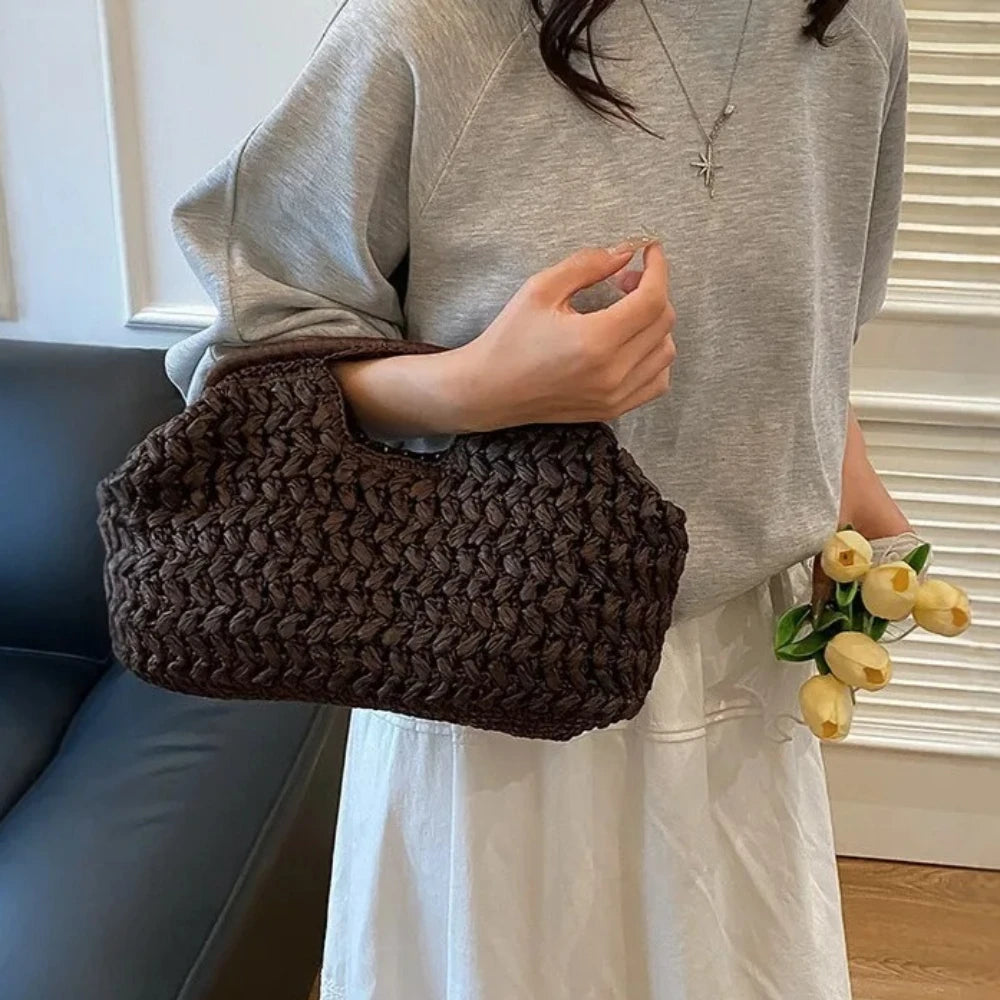 Person holding a brown textured handbag with a neutral background