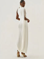 Woman wearing a white dress with long sleeves on a plain background