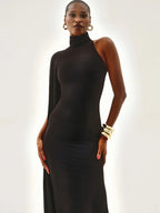Woman wearing a black high-neck dress against a white background