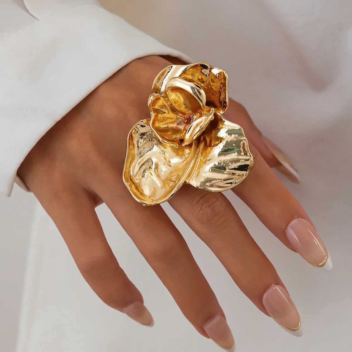 Gold ring on a hand against a neutral background