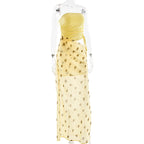 Yellow strapless dress with gold polka dots on a mannequin against a white background