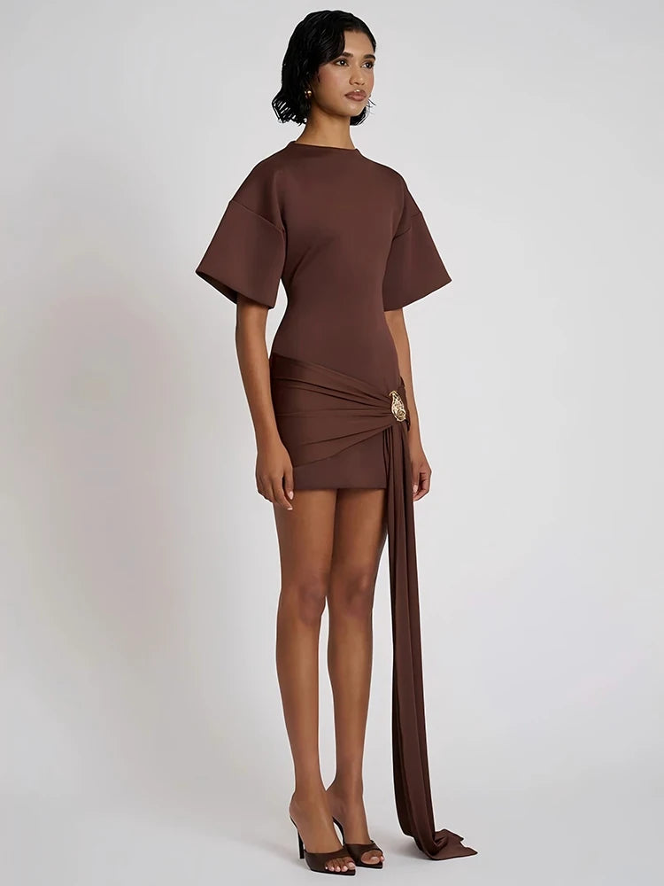 Woman wearing a brown outfit with a top and flowing pants on a white background