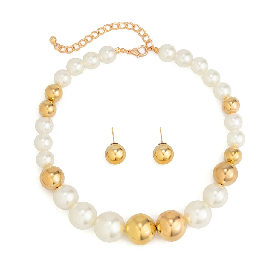 Pearl and gold necklace with matching earrings on a white background