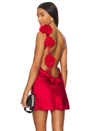 Woman wearing a red dress with floral back design on a white background