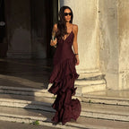 Woman in a burgundy dress standing on stone steps with classical architecture in the background