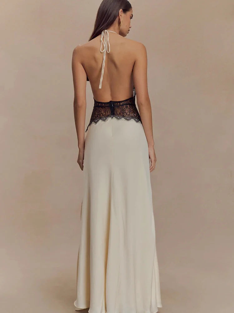 Woman wearing a long, elegant dress with a lace bodice on a beige background