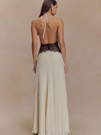 Woman wearing a long, elegant dress with a lace bodice on a beige background