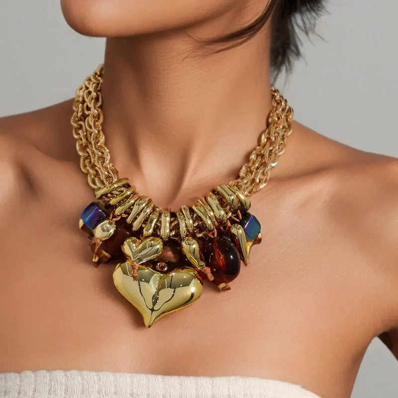 Gold necklace with heart pendants on a person against a neutral background