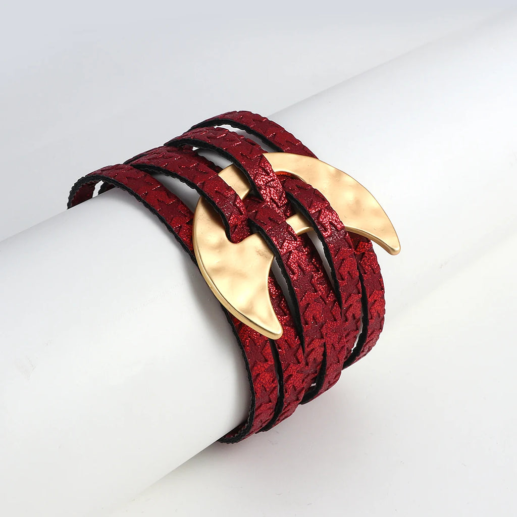 Red leather bracelet with gold claw-like ends on a white mannequin arm.