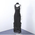 Black dress with white polka dots on a mannequin against a white background