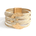 Multi-layered bracelet with gold and beige accents on a white background
