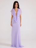 Woman wearing a lavender evening gown with a sheer overlay on a white background