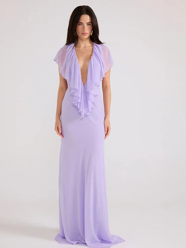 Woman wearing a lavender evening gown with a sheer overlay on a white background