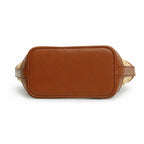 A brown leather belt bag shown from the back, featuring a smooth tan leather back panel and woven beige and brown patterned side straps, photographed on a solid white background.