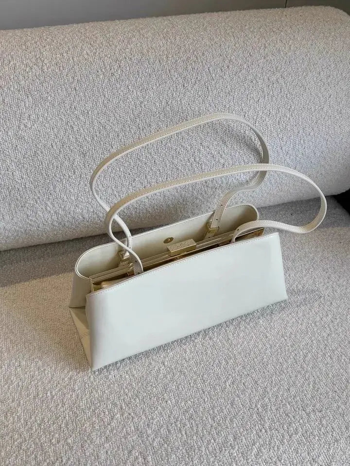 White handbag on a textured surface with a neutral background