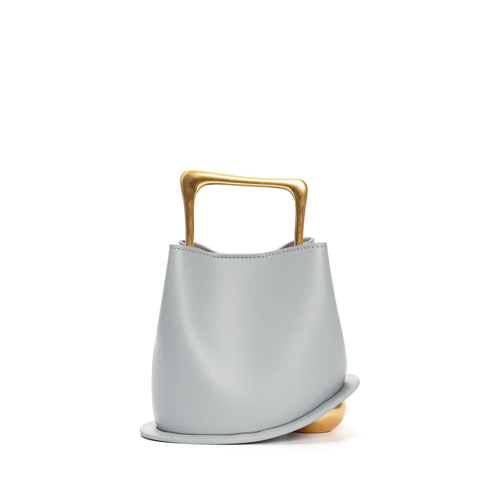 Light blue handbag with a gold handle on a white background