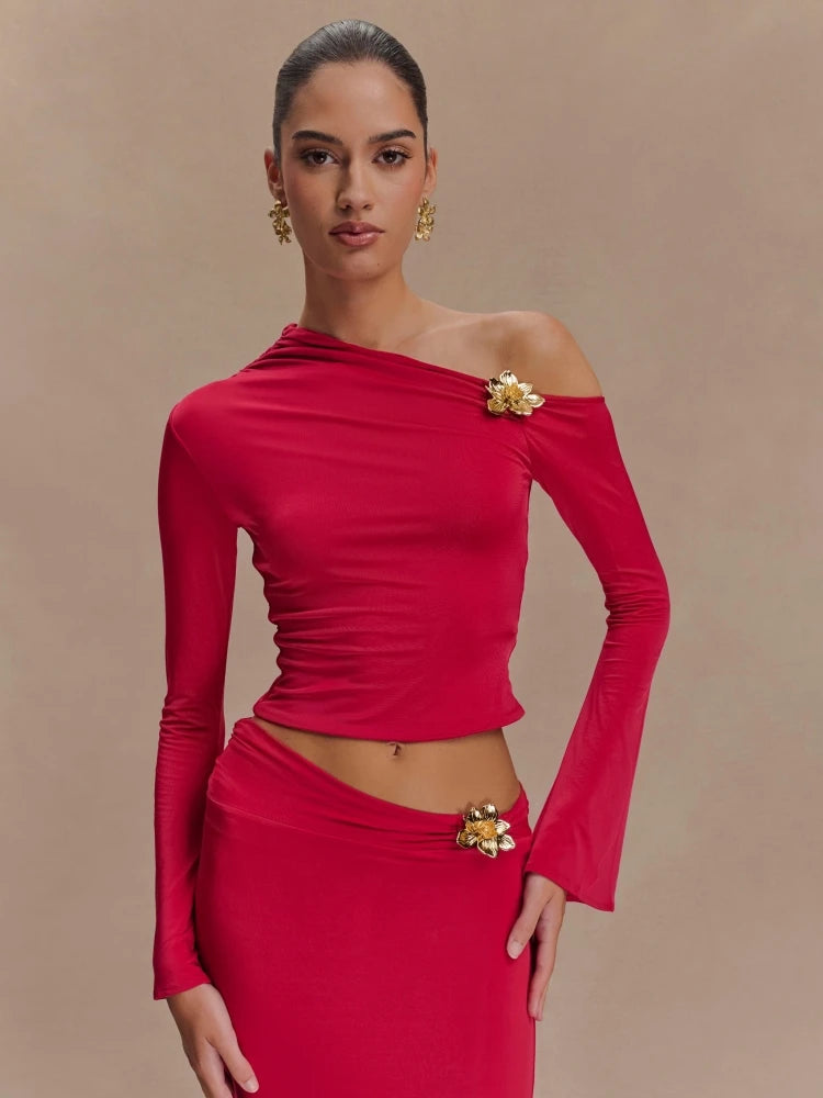 Woman wearing a red off-shoulder outfit with floral embellishments on a beige background