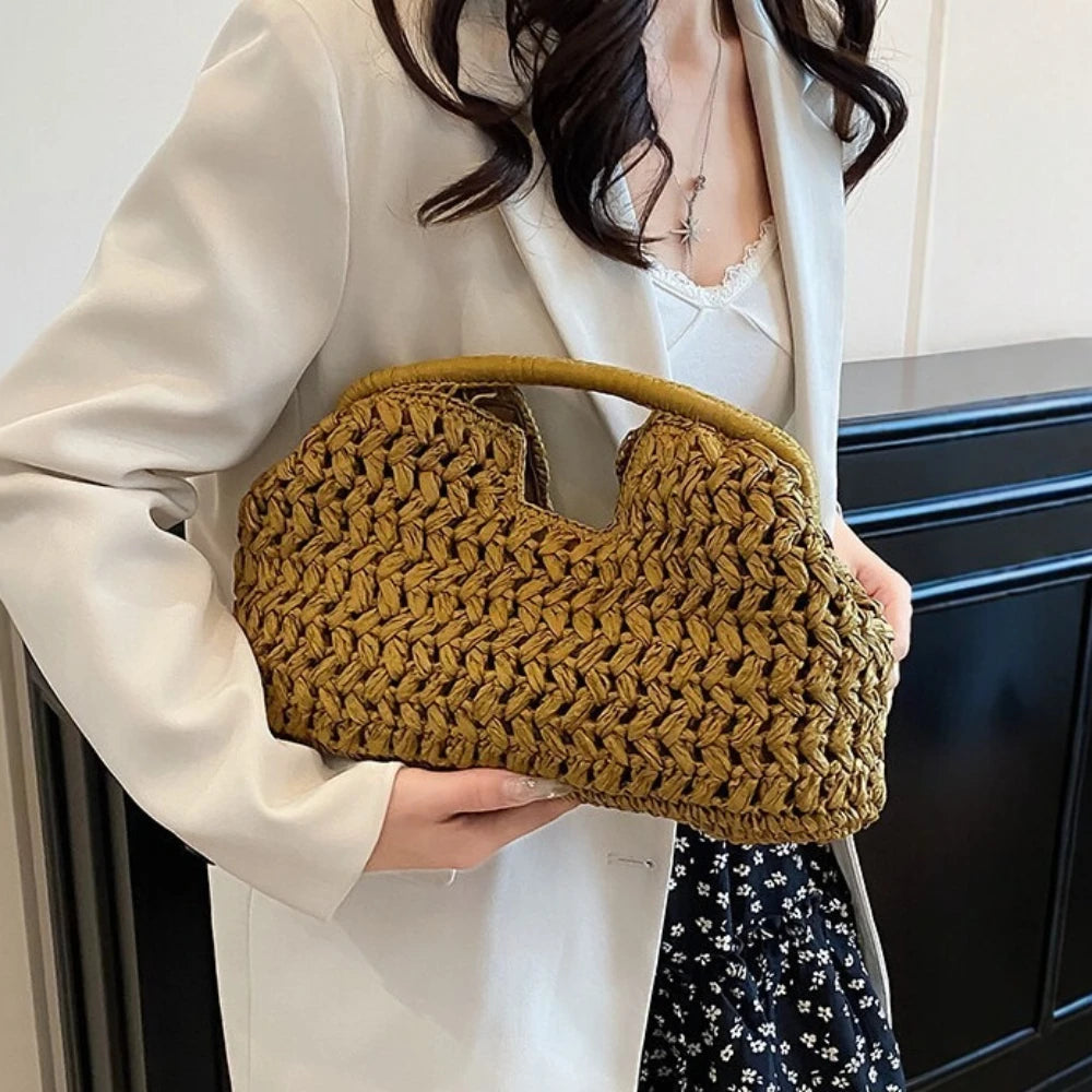 Person holding a brown woven handbag indoors