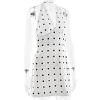 White sleeveless top with black polka dots on a white background