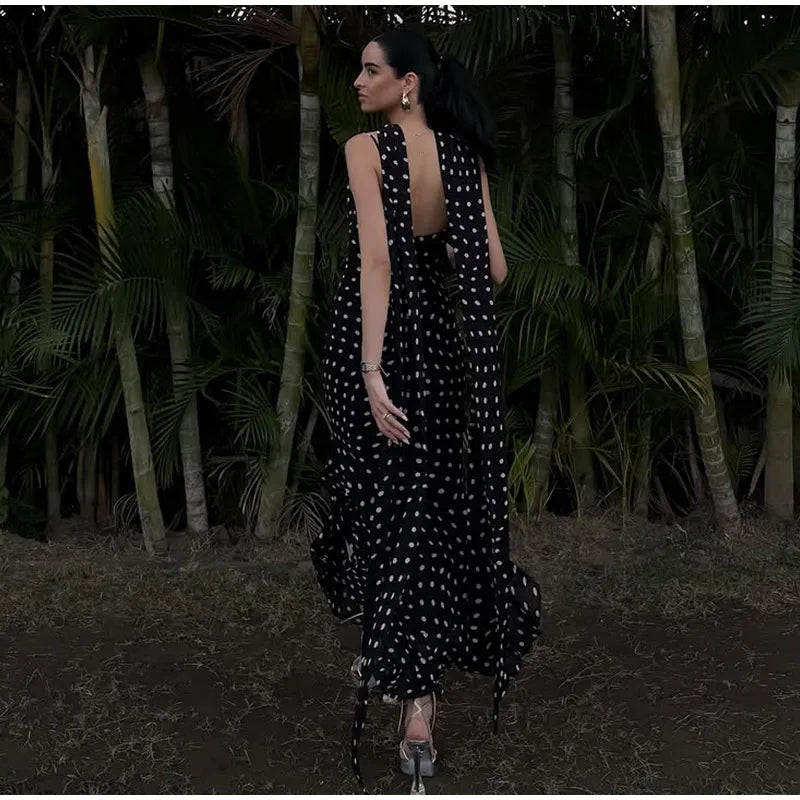 Woman in a black polka dot dress walking through a forest