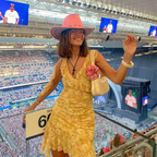 Woman in yellow dress and pink hat at a stadium event