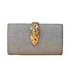 Silver textured clutch bag with a gold clasp on a beige background