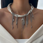 Necklace with pearls and silver chains on a person wearing a white top.