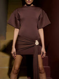 Brown dress with a belt worn by a model on a staircase