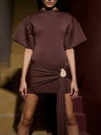 Brown dress with a belt worn by a model on a staircase