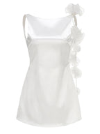 White satin camisole with ruffled details on a white background