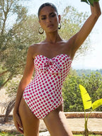 Woman wearing a polka dot swimsuit outdoors with trees in the background