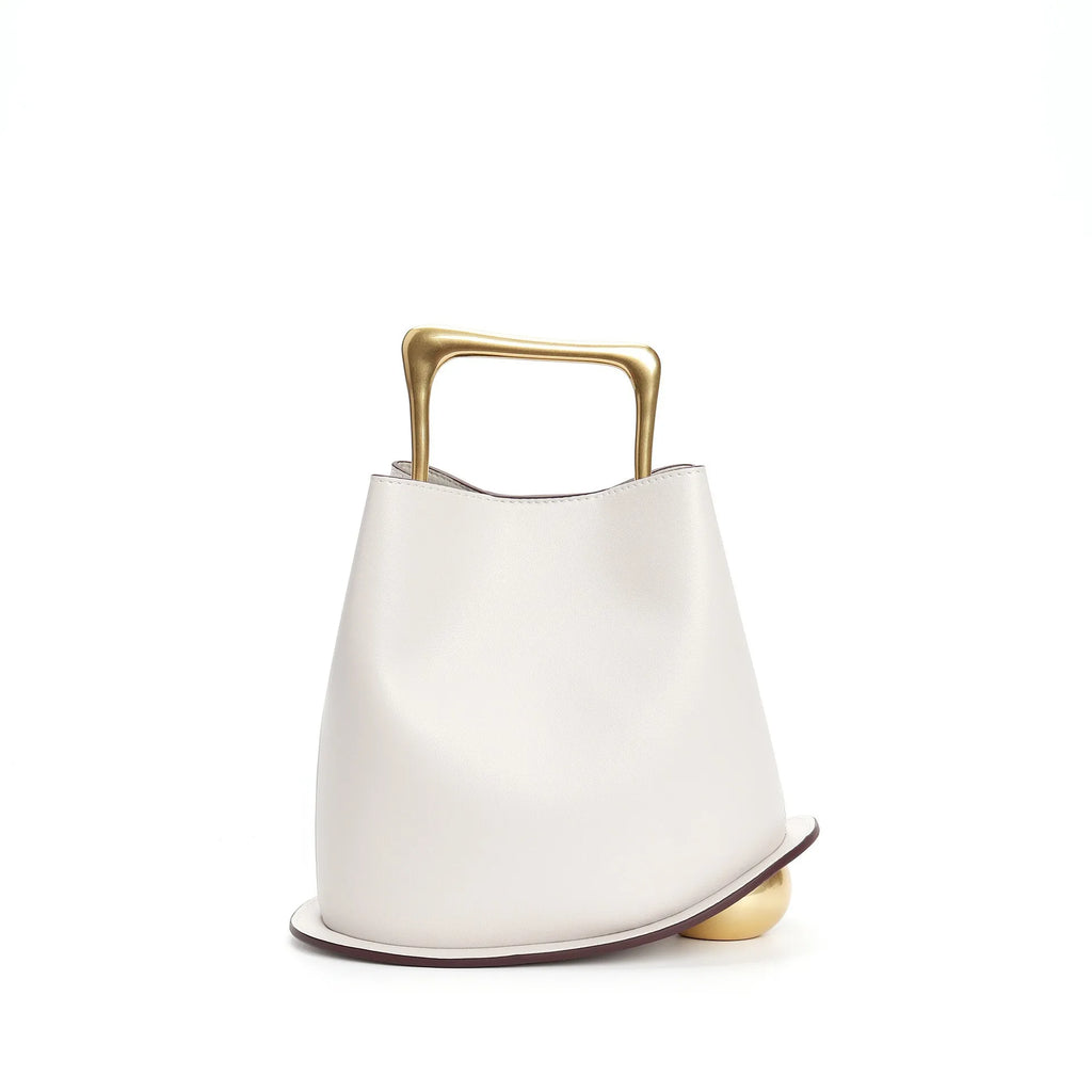 White ceramic vase with gold handle on a white background