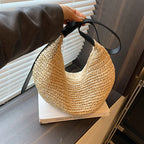 Woven handbag held by a person on a wooden surface