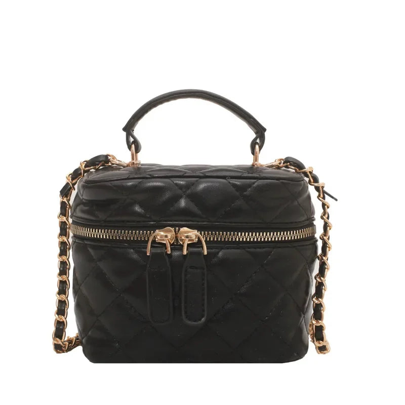 Black quilted handbag with gold chain strap on a white background