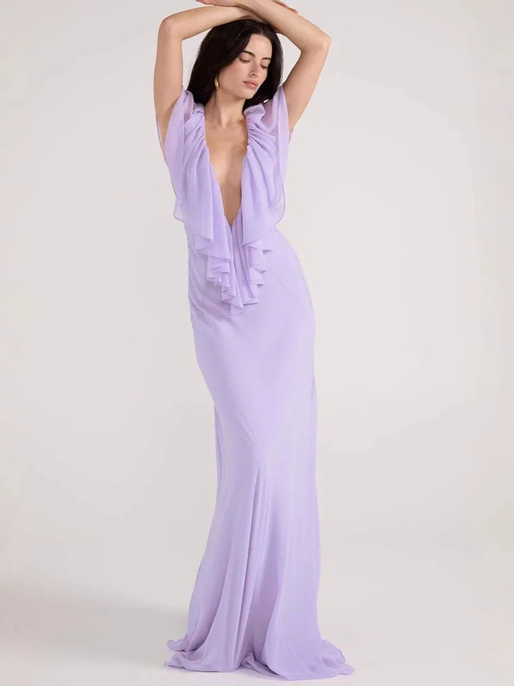 Woman wearing a long lavender dress against a white background