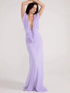 Woman wearing a long lavender dress against a white background